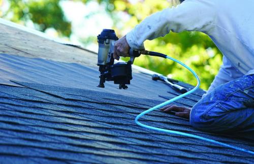 Roofer using a nail gun